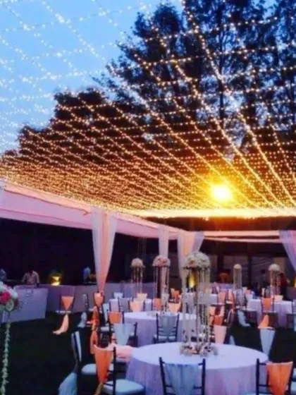 I create atmosphere with lighting, like this canopy of fairy lights for an outdoor dinner. This setup transforms a simple lawn into an elegant dining space, perfect for corporate dinners, receptions, or private parties.