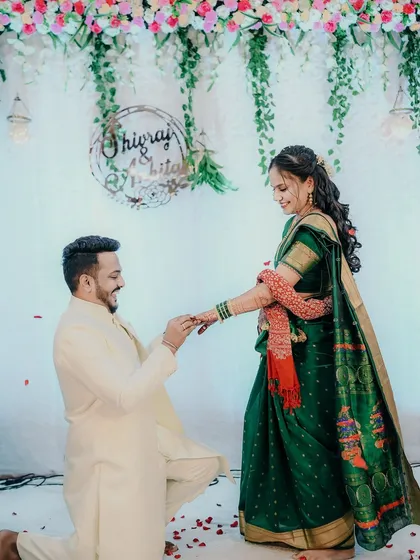 The ring exchange is a pivotal moment in any engagement ceremony. I focus on capturing the anticipation and happiness of this promise, with the beautiful floral decor and falling petals adding to the celebration. This is documenting a core memory.