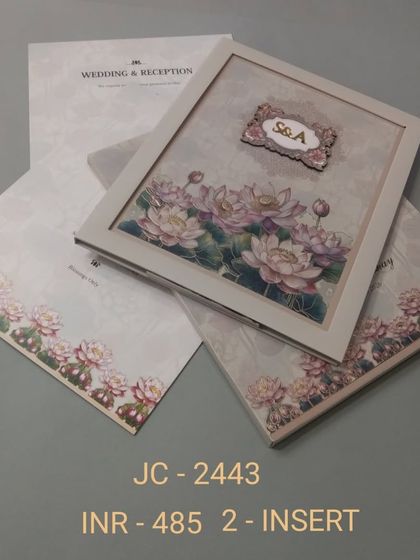 This invitation features a bed of 3D lotus flowers set within a simple frame. The design is serene and beautiful, with a custom monogram adding a personal touch.