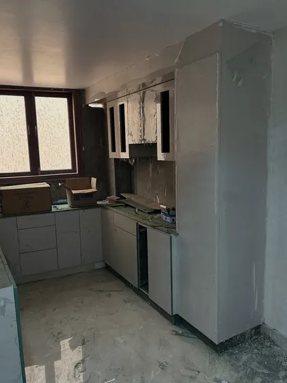 A wider shot of the kitchen during the fit-out stage. You can see the full layout taking shape, including the space for the chimney and the tall pantry unit.