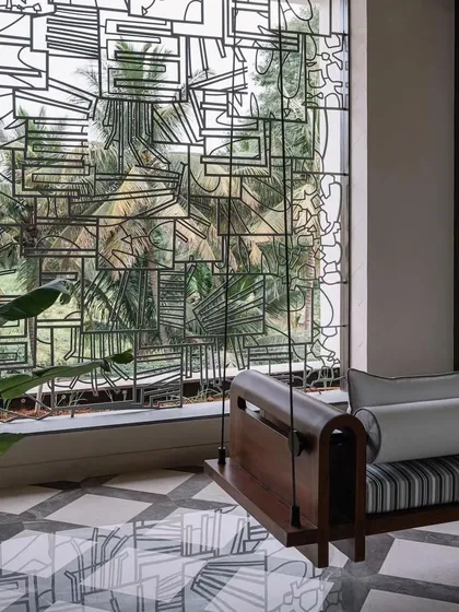 A closer look at the abstract metal window grill, showing how its geometric patterns create a visual dialogue with the lush greenery outside. The piece was designed to be both intellectually engaging and practical.