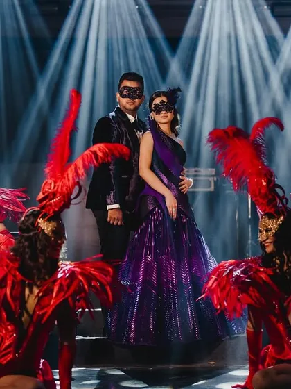 We brought a touch of midnight magic to this masquerade ball. I designed a custom deep purple velvet tuxedo for the groom to perfectly match the bride's structured gown, creating a dramatic and coordinated look for their enchanting evening celebration.