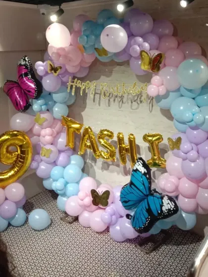 A whimsical butterfly-themed birthday for Tashi. This pastel balloon ring is decorated with beautiful, large butterfly foil balloons and personalized with a name and number, creating an enchanting photo spot.