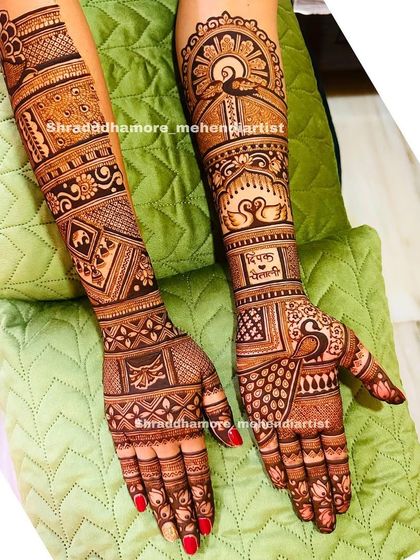 A personalized design with the couple's names 'Deepak' and 'Sakshi'. The arms feature a rising sun, swans, and intricate geometric work.