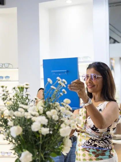 Our decor is designed to be part of the experience, not just a backdrop. Here at the GKB Opticals relaunch, a guest interacts with the products, framed by the soft white floral arrangements we placed throughout the store. This is what we aim for: creating an environment that feels natural, beautiful, and enhances the customer's journey.