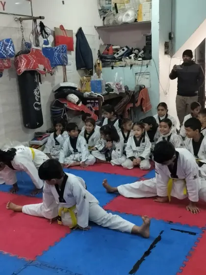 Students practicing splits as a group. Group stretching and fitness drills create a motivating and supportive environment.
