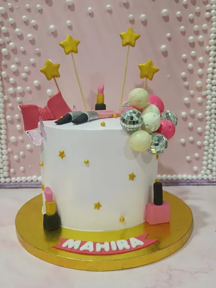 A chic makeup-themed cake. This design is decorated with edible lipstick, nail polish, and makeup brushes, perfect for a beauty lover.