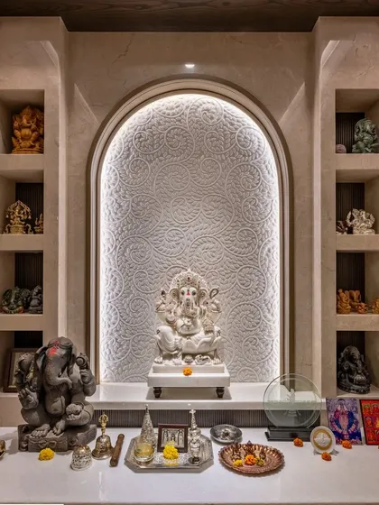 We design sacred spaces that are both modern and serene. This pooja room features an intricately carved marble backdrop with soft backlighting, creating a peaceful and divine focal point within the home.