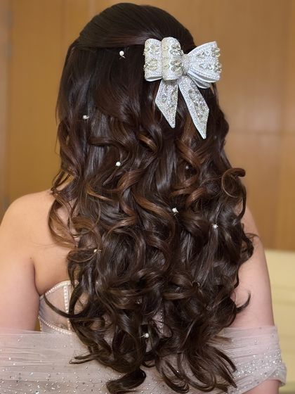 A detailed shot of the pearl and bow half-up hairstyle.