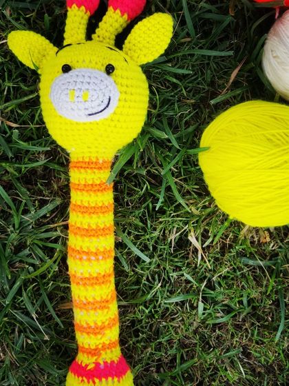 A bright and cheerful giraffe rattle, perfect for stimulating a baby's senses. The long neck is easy for little hands to grab, and the vibrant colors are visually engaging.