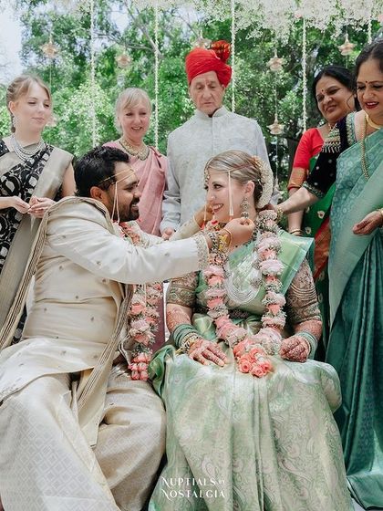 The groom ties the sacred thread around the bride's neck, with family from both sides looking on with love.
