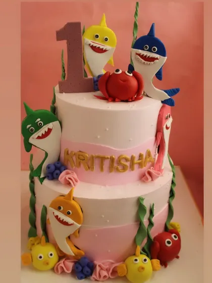 A close-up of the Baby Shark cake, showing the intricate details of the fondant characters and underwater theme.