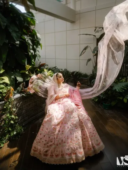 Archana seated in a sunlit atrium, her veil catching the air. This shot is full of movement and light, creating a breathtaking portrait that feels both grand and ethereal.