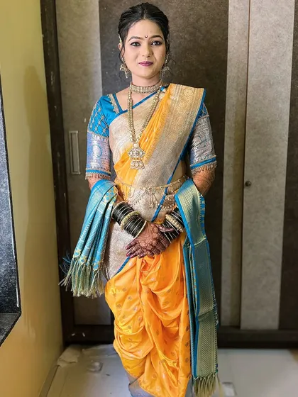 Draping a Nauvari saree is an art in itself. Here, I have styled my client in a traditional yellow and blue Nauvari, ensuring the drape is perfect and comfortable, allowing her to move with grace during her saptapadi ceremony.