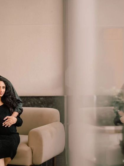 A moody and artistic indoor maternity portrait. The reflection in the glass adds a layer of depth and thoughtfulness to this intimate moment.