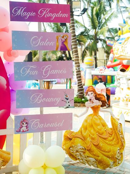 A themed signpost directs guests to the "Magic Kingdom," "Salon," "Bouncy," and "Carousel."