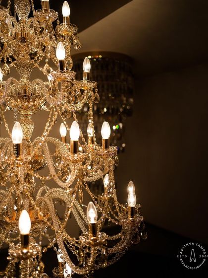A detailed look at our magnificent multi-tiered crystal chandelier. Each arm is draped with shimmering crystal beads that reflect and refract light, creating an unparalleled sparkle. This fixture is a testament to classic European design and meticulous craftsmanship.