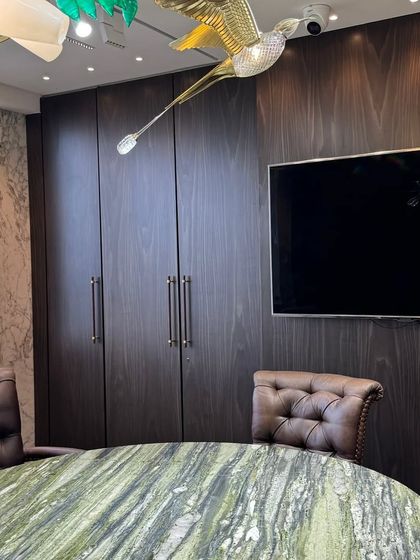 Functionality meets style with these dark wood-paneled cabinets, providing ample storage while seamlessly integrating a large screen for presentations in the conference room.