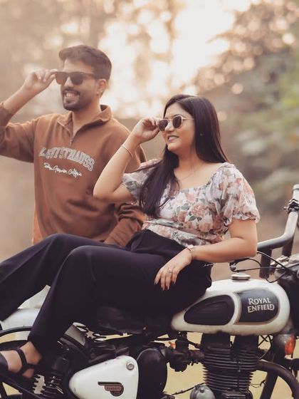 A cool and edgy pre-wedding shot featuring a Royal Enfield bike. This kind of prop adds a lot of personality and makes for a really memorable and stylish couple portrait.