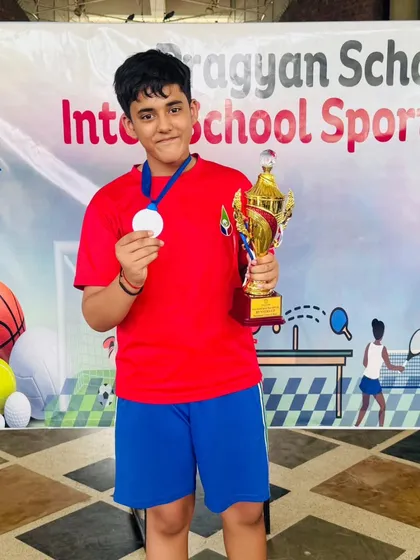 Pulkit Sugara proudly displays his silver medal and trophy from the Badminton Inter-School Sports Meet. His success is a direct result of his hard work and our rigorous training program.