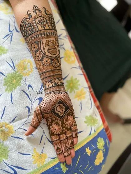A side view of a custom bridal mehandi, showing how the different bands of patterns wrap around the arm. You can see the peacock, kalash, and elephant motifs clearly.