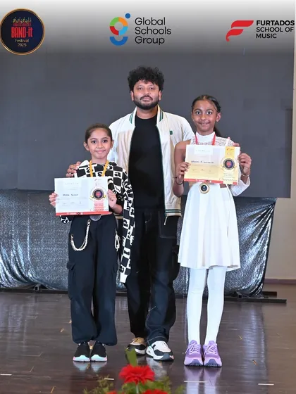 Two young winners from the Bangalore Band-It competition proudly pose with their certificates and medals. This image captures the sense of achievement and joy that our platform brings to young artists.