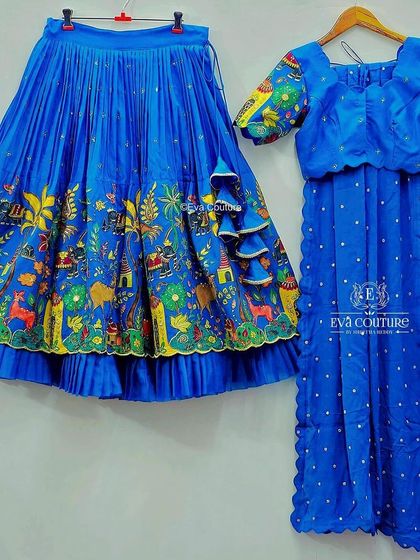 A blue Kalamkari lehenga with a story-like print, paired with a matching blouse and dupatta.