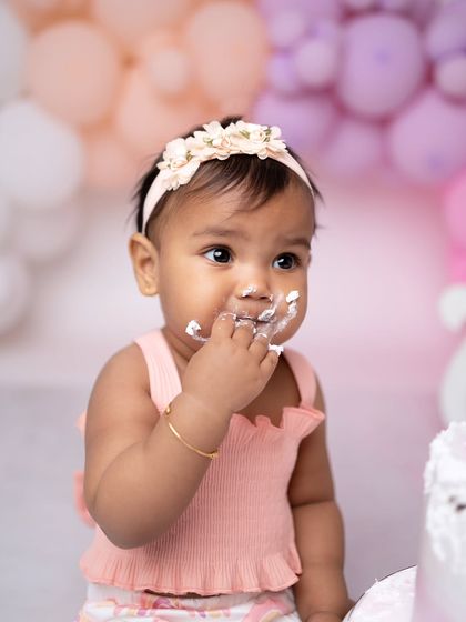 A detailed close-up capturing her sweet expression and the frosting on her fingers.