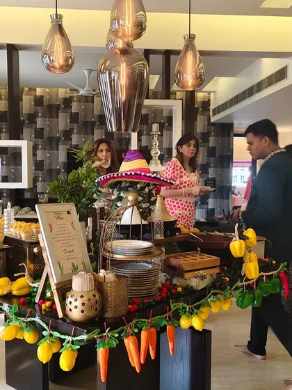 A wider view of the Mexican fiesta setup, showing guests enjoying the spread. Our grazing tables are designed to be interactive, encouraging guests to mingle as they sample the different offerings.