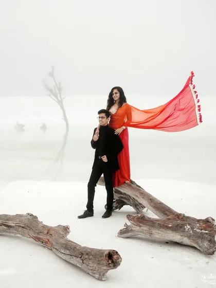 We love discovering surreal landscapes for our couples. Here, in the stark white marble quarries near Udaipur, a vibrant red gown creates a breathtaking contrast, turning a pre-wedding portrait into a piece of high-fashion art.
