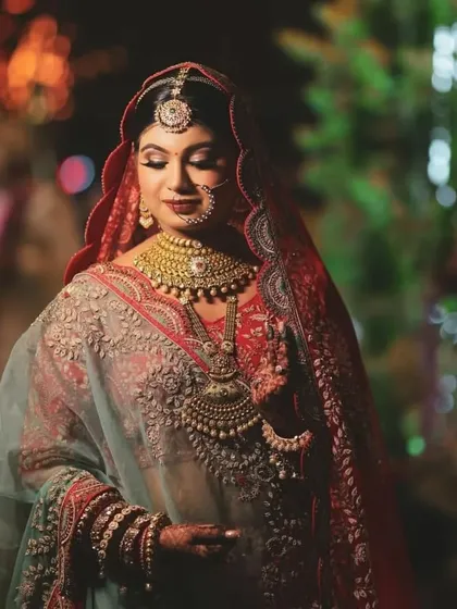 A close-up portrait of a bride with her eyes closed, highlighting her intricate jewelry and the soft glow of the evening lights.