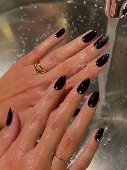 A sleek and chic glossy black manicure. This is a bold, edgy, and sophisticated look that pairs well with everything.