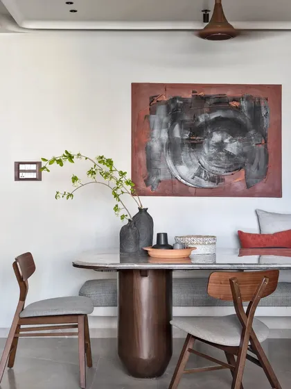 I call this visual poetry. The abstract artwork, custom bench seating, and sculptural dining table create a scene that is impactful yet calming, perfect for shared meals.