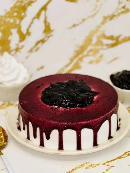 I call this my Blueberry Bomb cake. A simple white cake is topped with a generous amount of rich blueberry compote, which drips down the sides. It's a burst of fruity flavor in every bite.