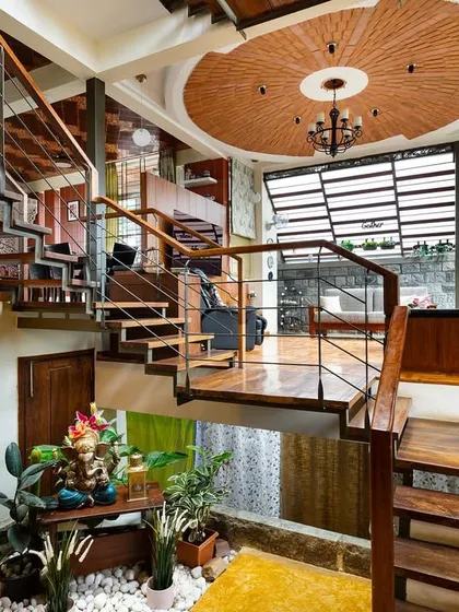 This angle shows the intricate network of staircases that connect the different areas of the home. The design creates an open, flowing experience, where you can see from the ground floor courtyard all the way up to the terracotta-tiled ceiling.