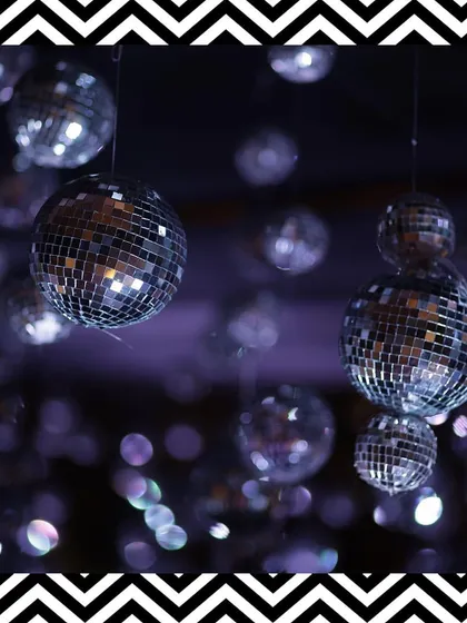 We hung dozens of disco balls from the ceiling to add a touch of retro glamour and sparkle to the black and white Sangeet night.