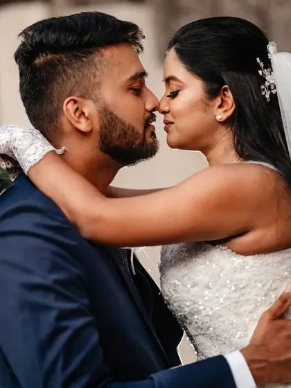 A close-up portrait capturing the intimacy of a near-kiss. This shot focuses on their connection, with the bride's blue bouquet adding a beautiful pop of color.