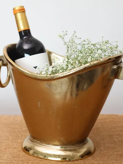 Our classic brass champagne bucket, styled simply with a bottle of wine and delicate baby's breath. This demonstrates the timeless elegance of the bucket as a standalone piece or a gift base.