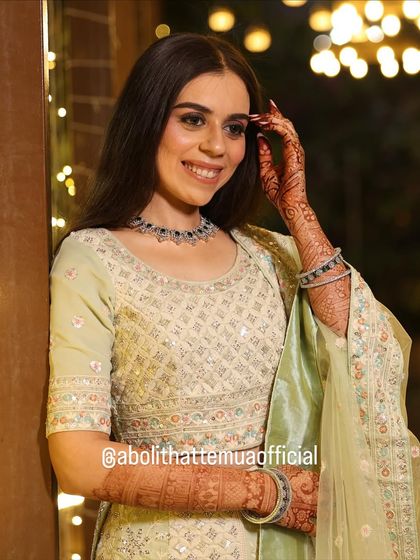 A radiant look for an evening engagement party. The makeup features a soft glam eye and glowing skin, perfectly complementing her pastel green lehenga.