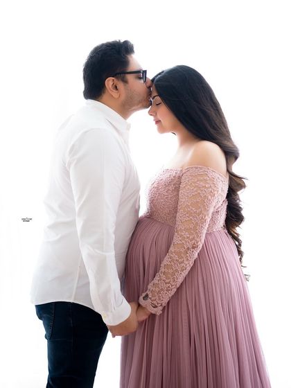 A sweet forehead kiss in a high-key setting. The soft pink gown and the gentle light create a very romantic and dreamy atmosphere.