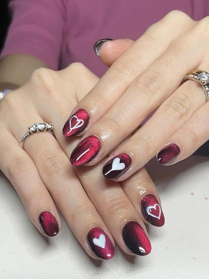 A red cat-eye base with hand-painted white hearts. This is a sweet and romantic design, perfect for Valentine's Day or any time of year.