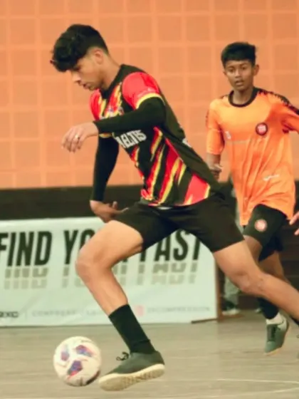 An action shot from the Delhi Futsal League. One of our players skillfully maneuvers through defenders, demonstrating the close-quarters ball control that is essential in futsal.