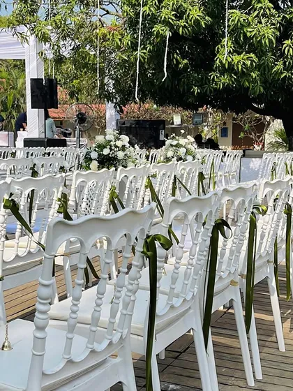 The seating arrangement for the white-themed wedding, with green ribbons adding a subtle pop of color and elegance.