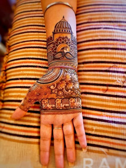 An intricate design on the back of the hand featuring a palace dome, peacocks, and a procession of elephants. This is perfect for someone who loves royal and traditional Rajasthani motifs.