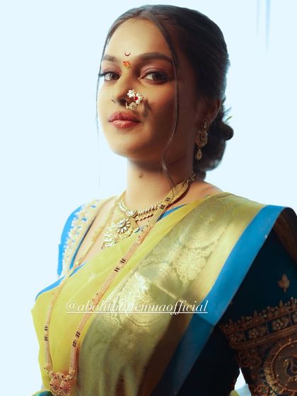 A powerful and artistic portrait of a bride. The lighting highlights the contouring and the traditional chandrakor bindi, creating a regal look.