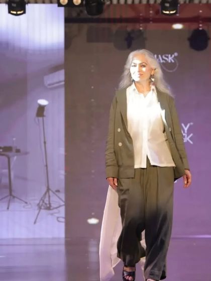 A full view of the celebrity actor on the runway. The makeup complements the high-fashion outfit, creating a cohesive and powerful statement.