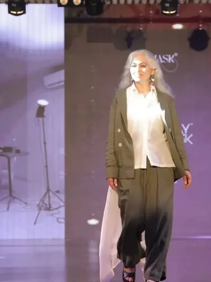 A full view of the celebrity actor on the runway. The makeup complements the high-fashion outfit, creating a cohesive and powerful statement.