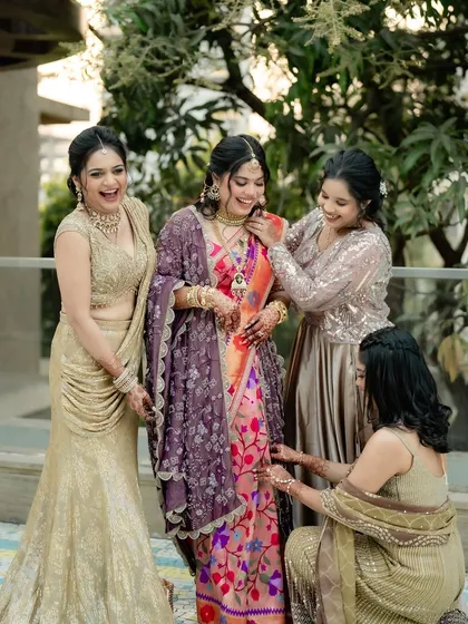 A beautiful moment between the bride and her bridesmaids. Her soft and authentic makeup look stands out, blending perfectly with the traditional Maharashtrian style.
