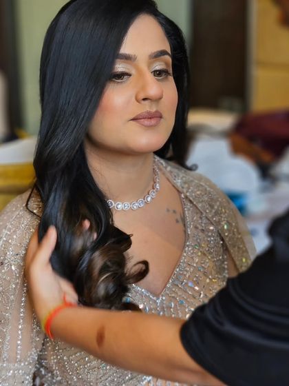 A behind-the-scenes moment. The soft waves in her hair complement the gentle and romantic makeup look.