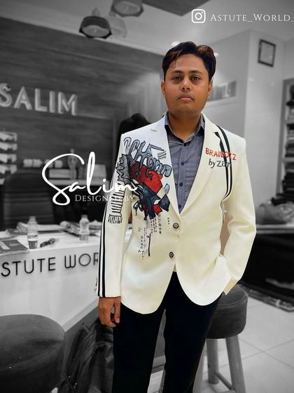 The designer himself wearing a custom hand-painted white blazer with abstract art and lettering. This piece showcases a modern, edgy approach to formal wear.